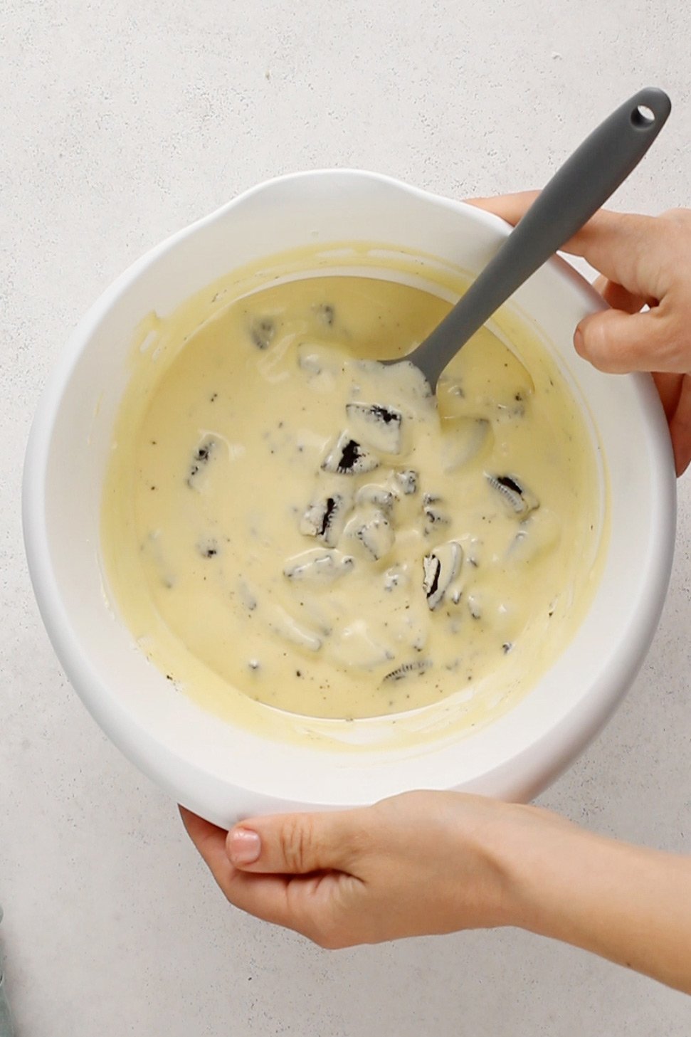 Batter for oreo cheesecake bars in a white mixing bowl.