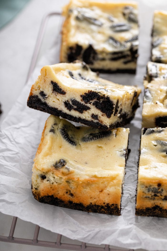 Side of of a sliced oreo cheesecake bar, showing the oreo cookies throughout the batter.