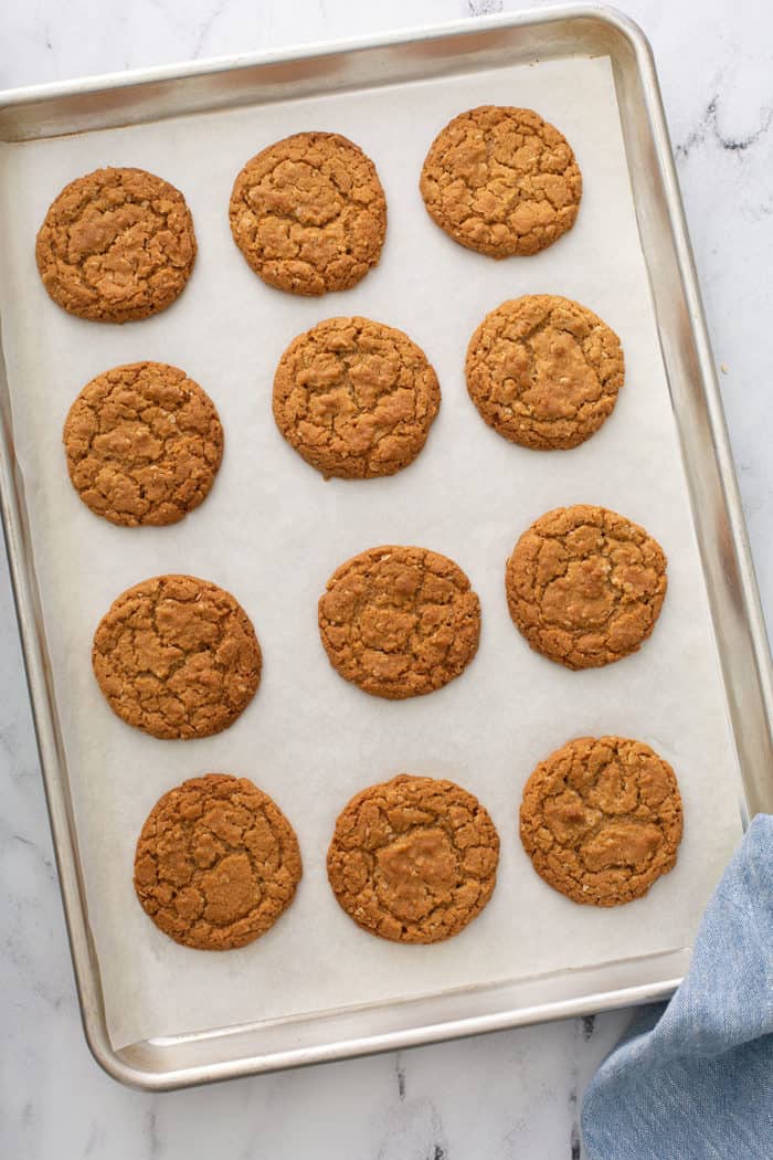 Baked biscoff cookies cooling on a parchment-lined sheet pan