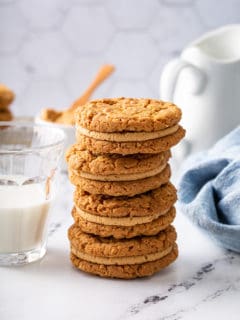 Four biscoff sandwich cookies stacked on a marble countertop