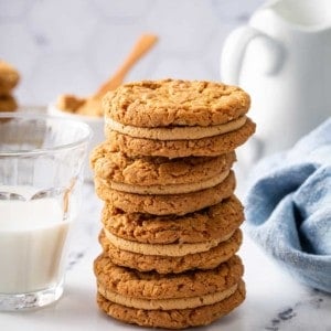 Four biscoff sandwich cookies stacked on a marble countertop