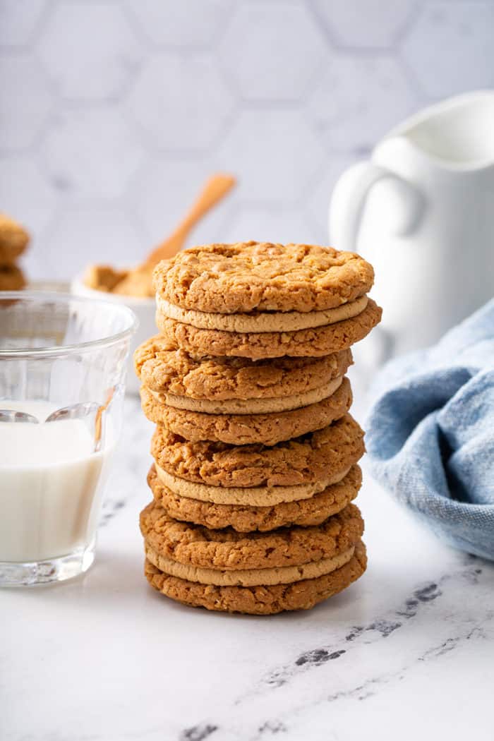 Four biscoff sandwich cookies stacked on a marble countertop