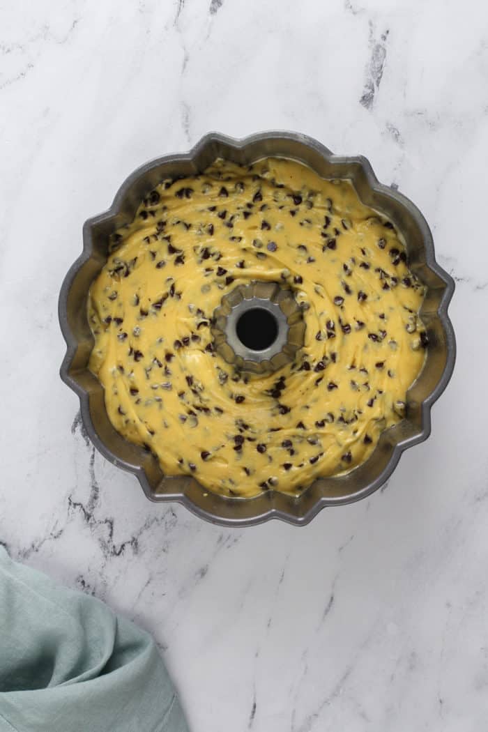 Unbaked chocolate chip bundt cake batter in a bundt pan, ready to go in the oven.