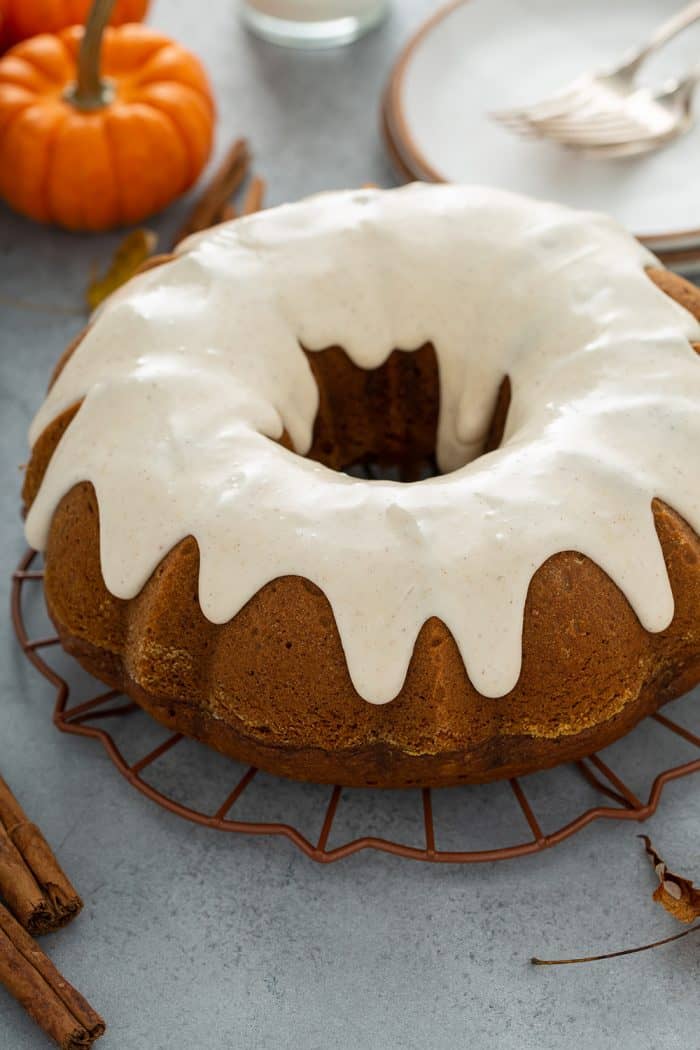 Frosted pumpkin bundt cake on a wire rack