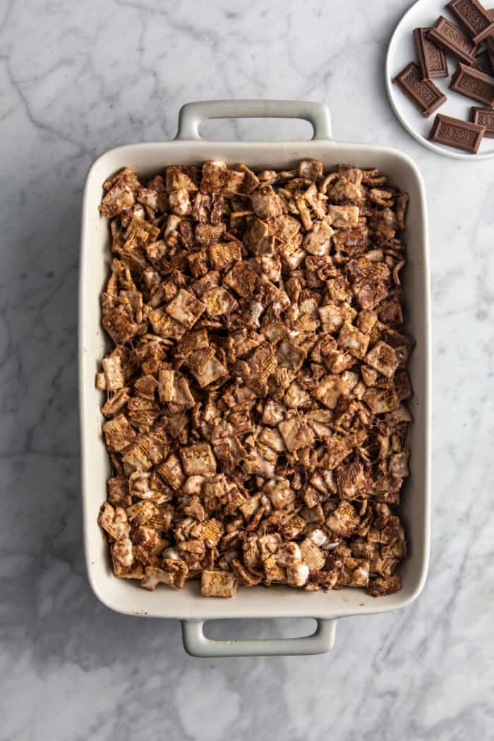 Base for golden graham s'mores pressed into a white baking dish.