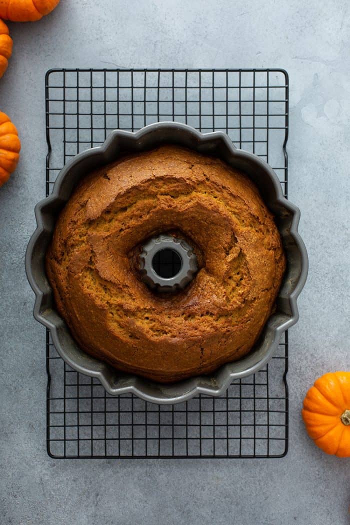 Baked pumpkin cake in a bundt pan on a wire rack