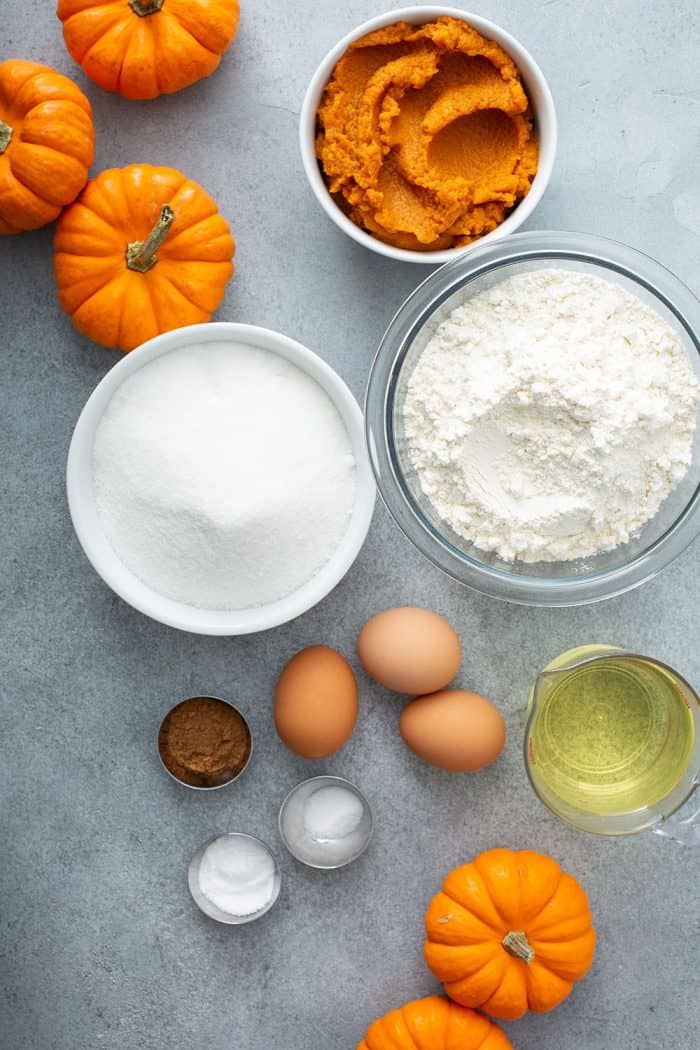 Ingredients for pumpkin bundt cake arranged on a gray counter