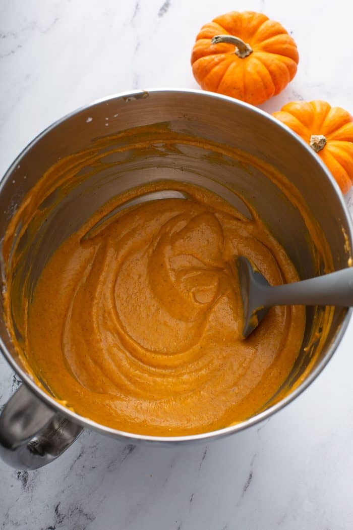 Pumpkin dip and a spatula in a metal mixing bowl