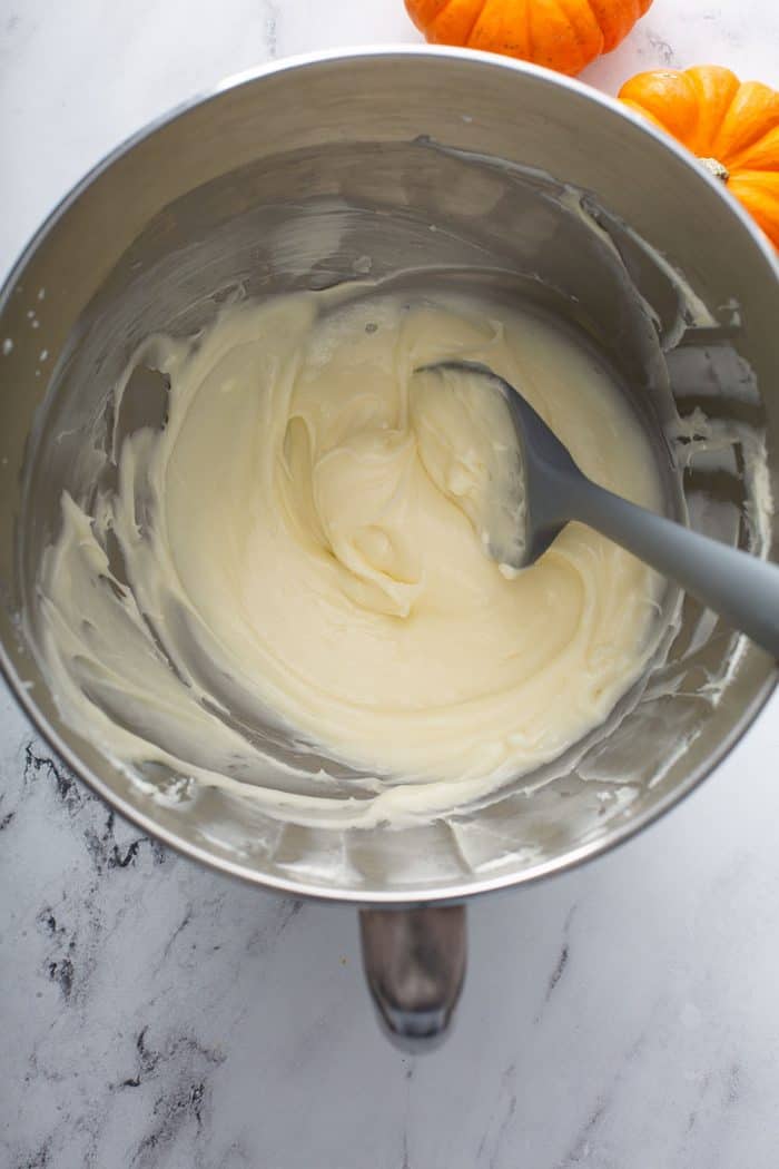 Cream cheese mixed with confectioners sugar in a metal mixing bowl