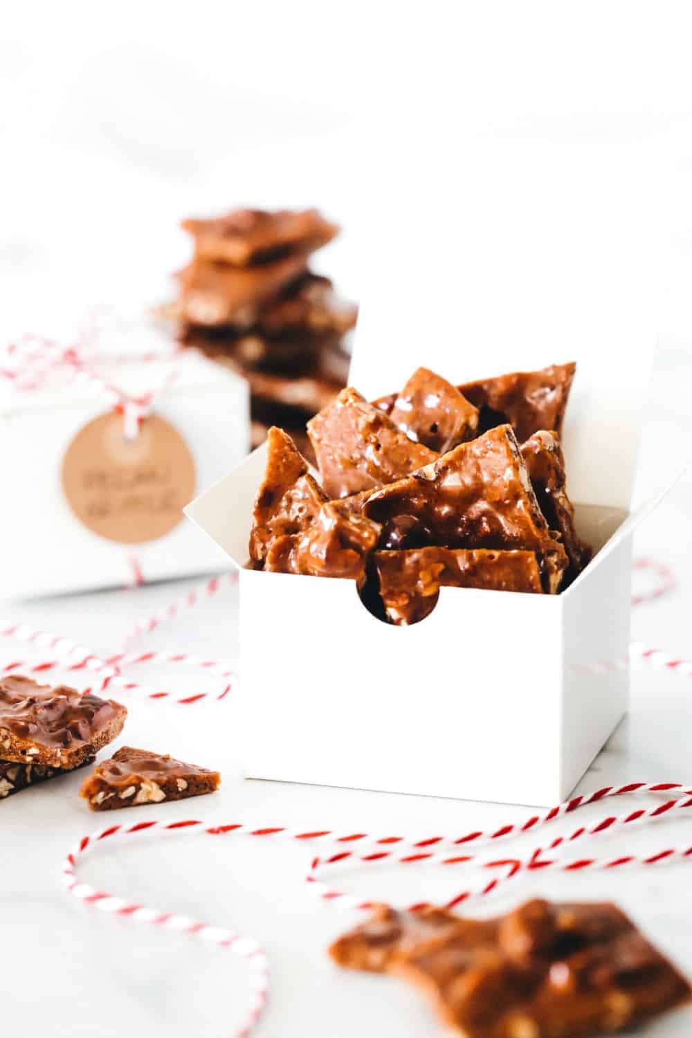 Pieces of pecan brittle arranged in white boxes for gifting