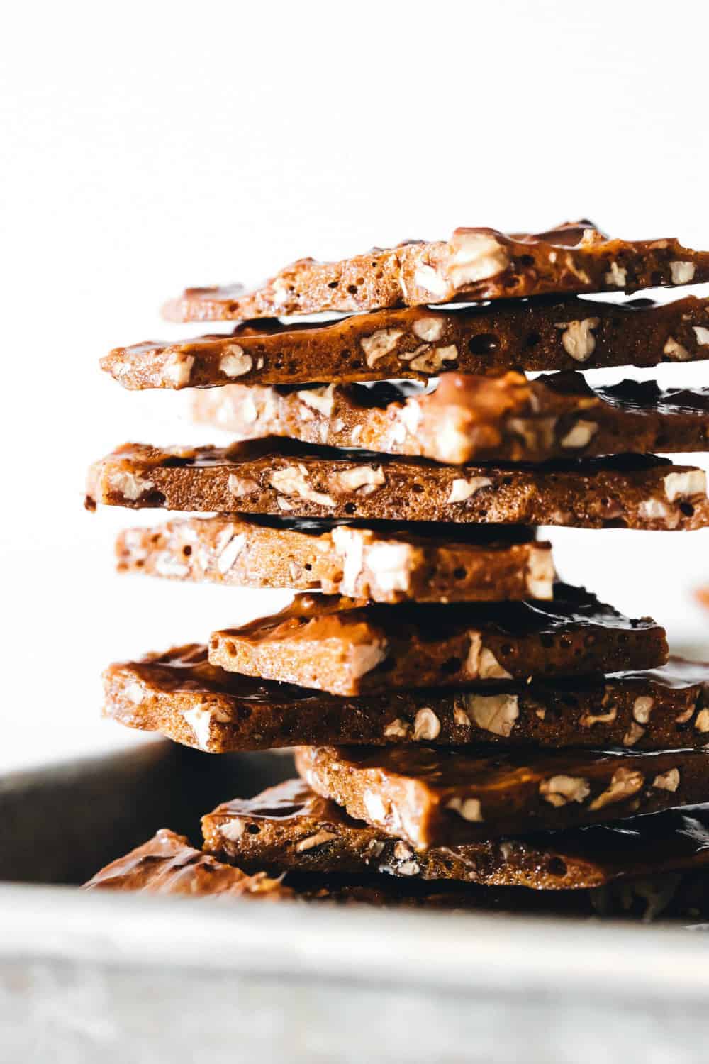 Stacked pieces of pecan brittle on a sheet tray