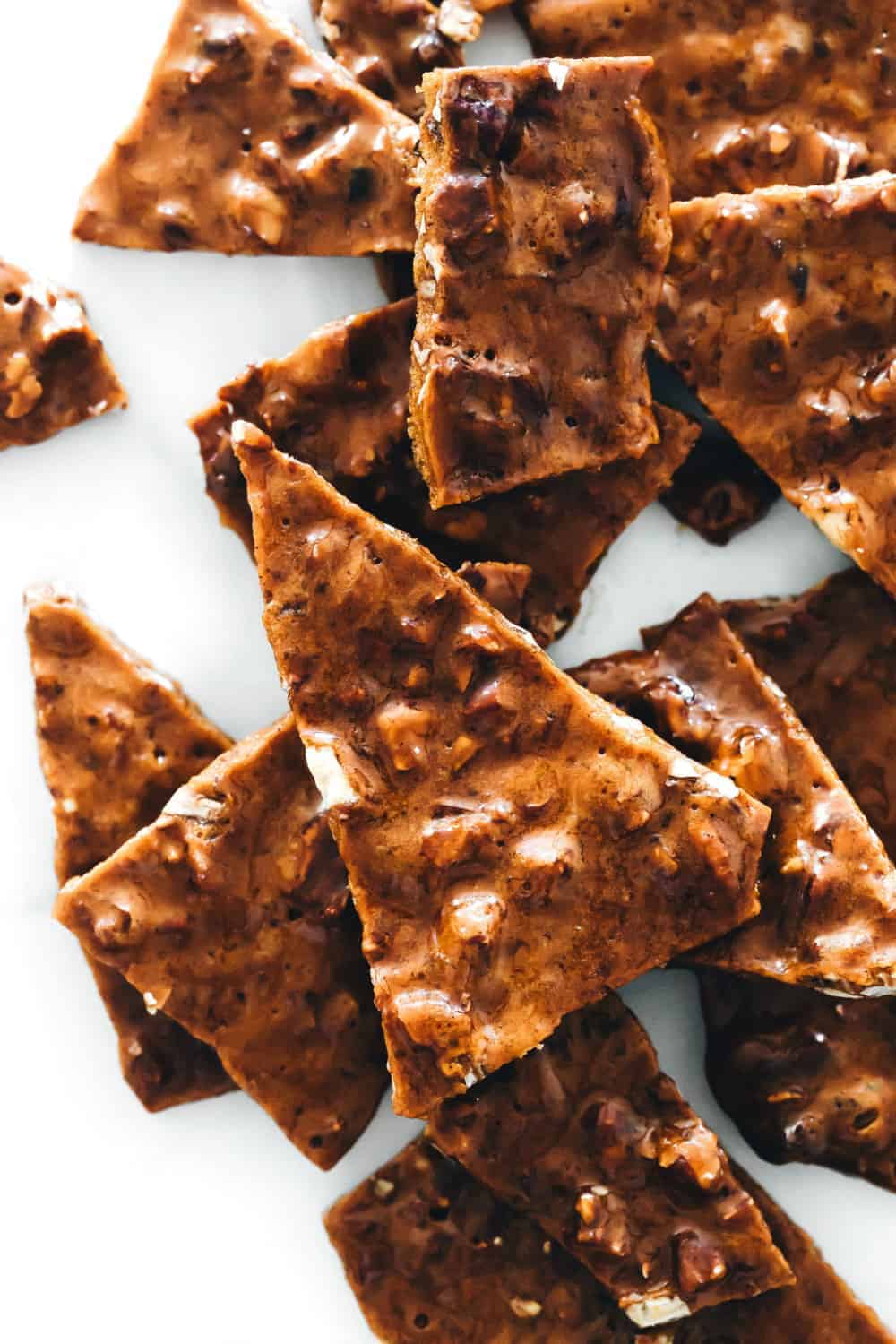 Shards of pecan brittle on a piece of parchment paper