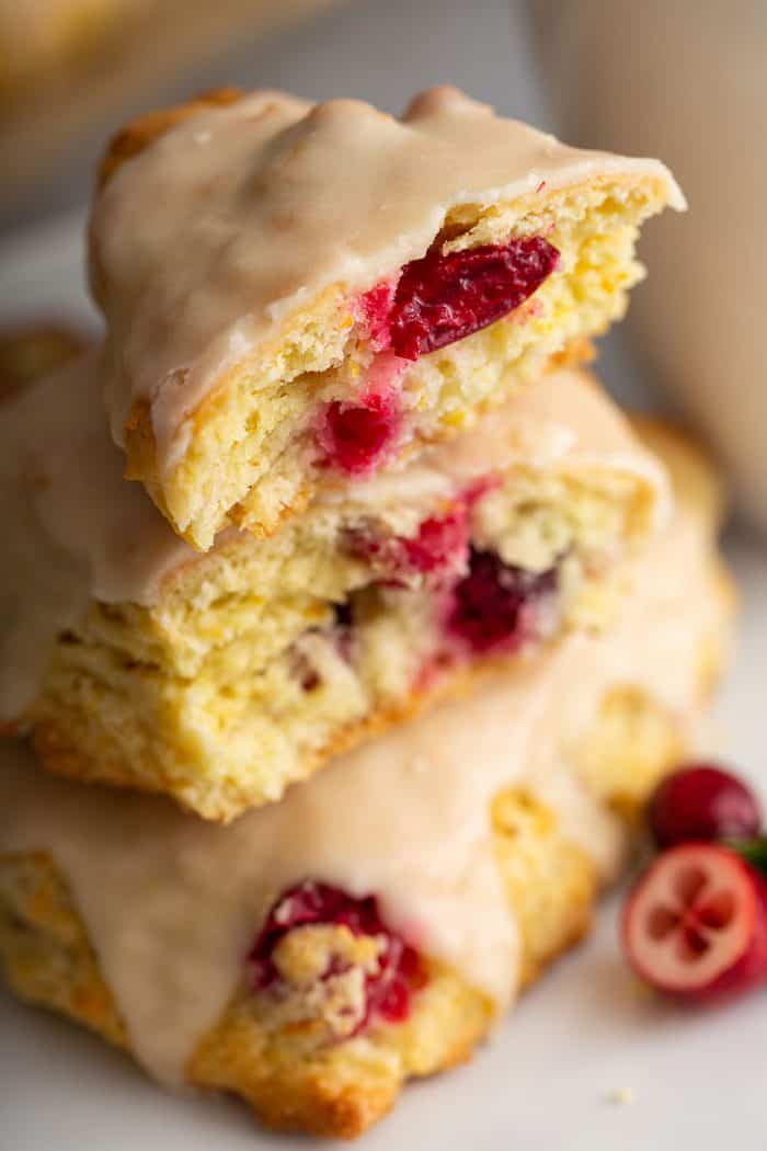 Two halves of a cranberry orange scone stacked on a plate to show the texture of the inside of the scone