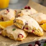 Cranberry orange scones stacked on a piece of parchment paper