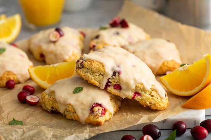 Cranberry orange scones stacked on a piece of parchment paper