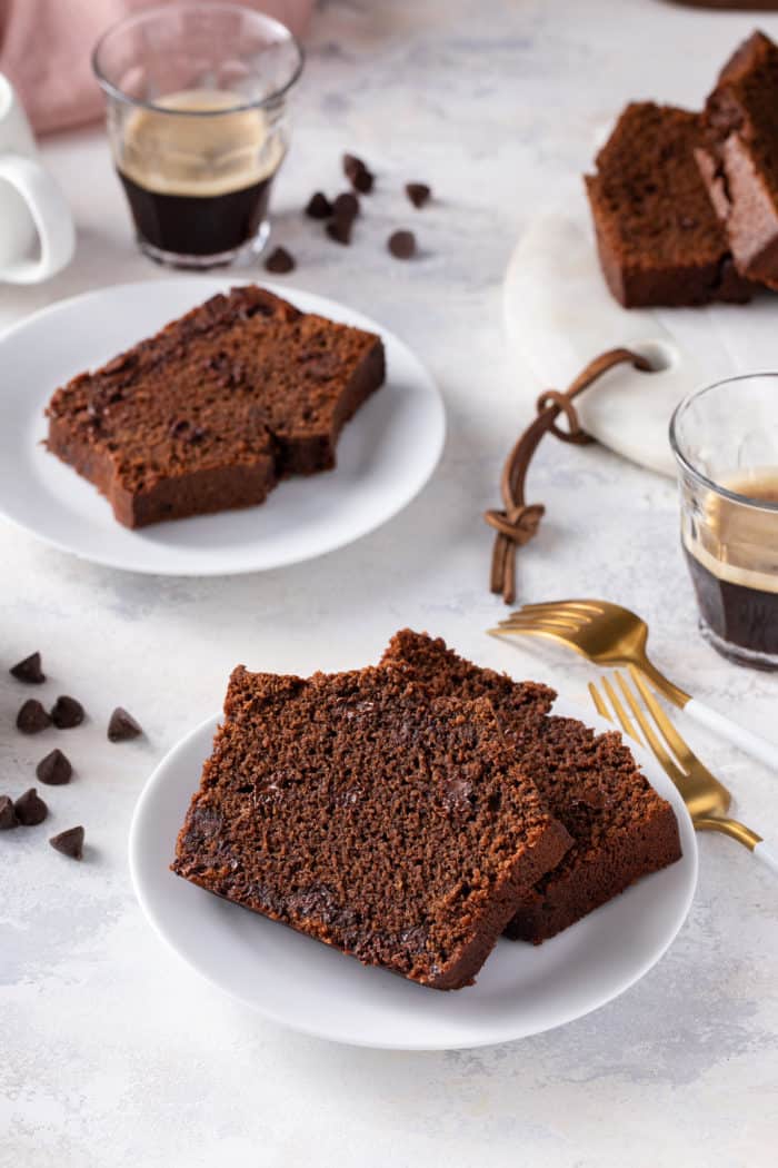 Two white plates with slices of chocolate bread on them.