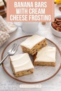 Three pieces of frosted banana bars arranged next to a fork on a stoneware plate. Text overlay includes recipe name.