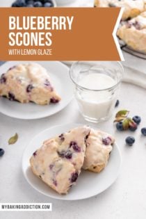 Two white plates with glazed blueberry scones next to a glass of milk. Text overlay includes recipe name.