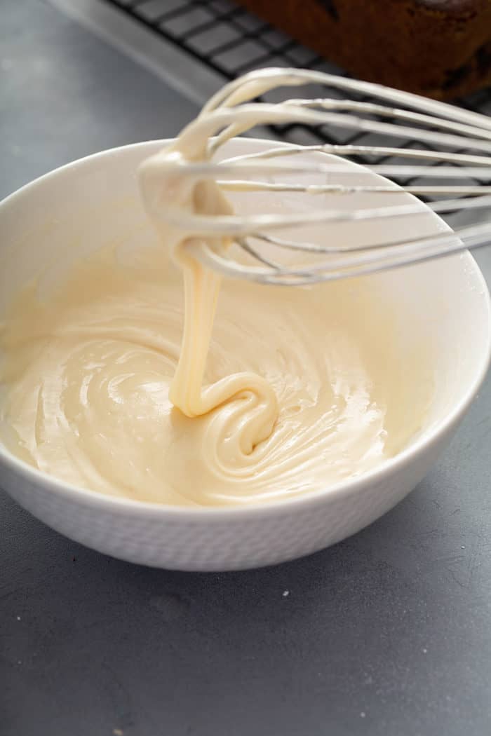 Whisk stirring together lemon glaze in a white bowl