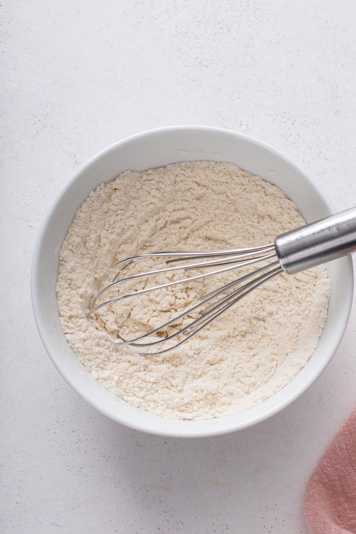 Dry ingredients for strawberry rhubarb cake whisked in a mixing bowl.