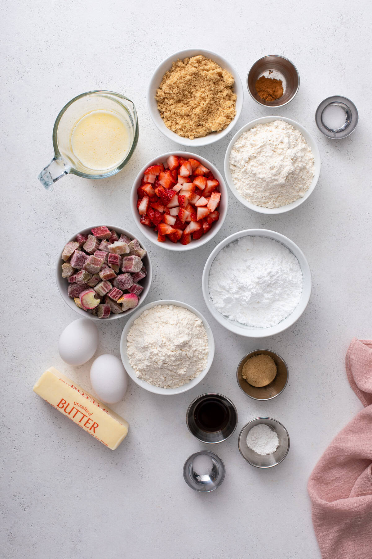 Ingredients for strawberry rhubarb cake arranged on a countertop.