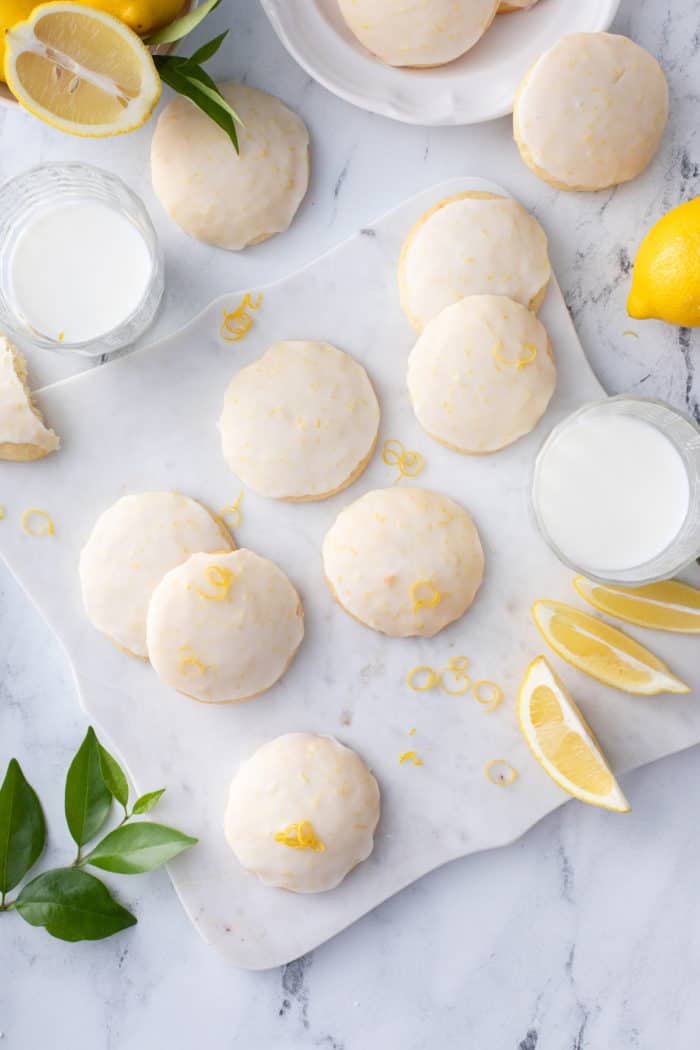Glazed lemon ricotta cookies scattered in a piece of parchment paper.