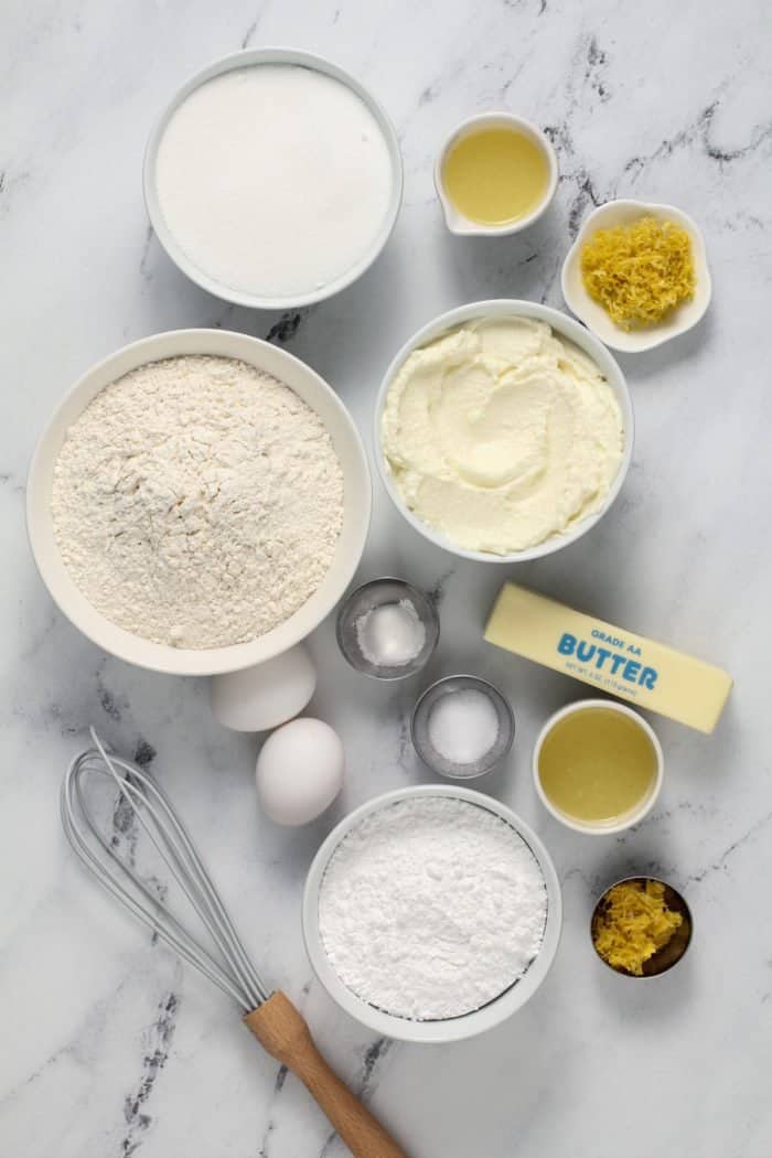 Ingredients for lemon ricotta cookies arranged on a marble countertop.