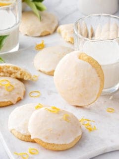 Lemon ricotta cookies arranged next to a glass of milk.