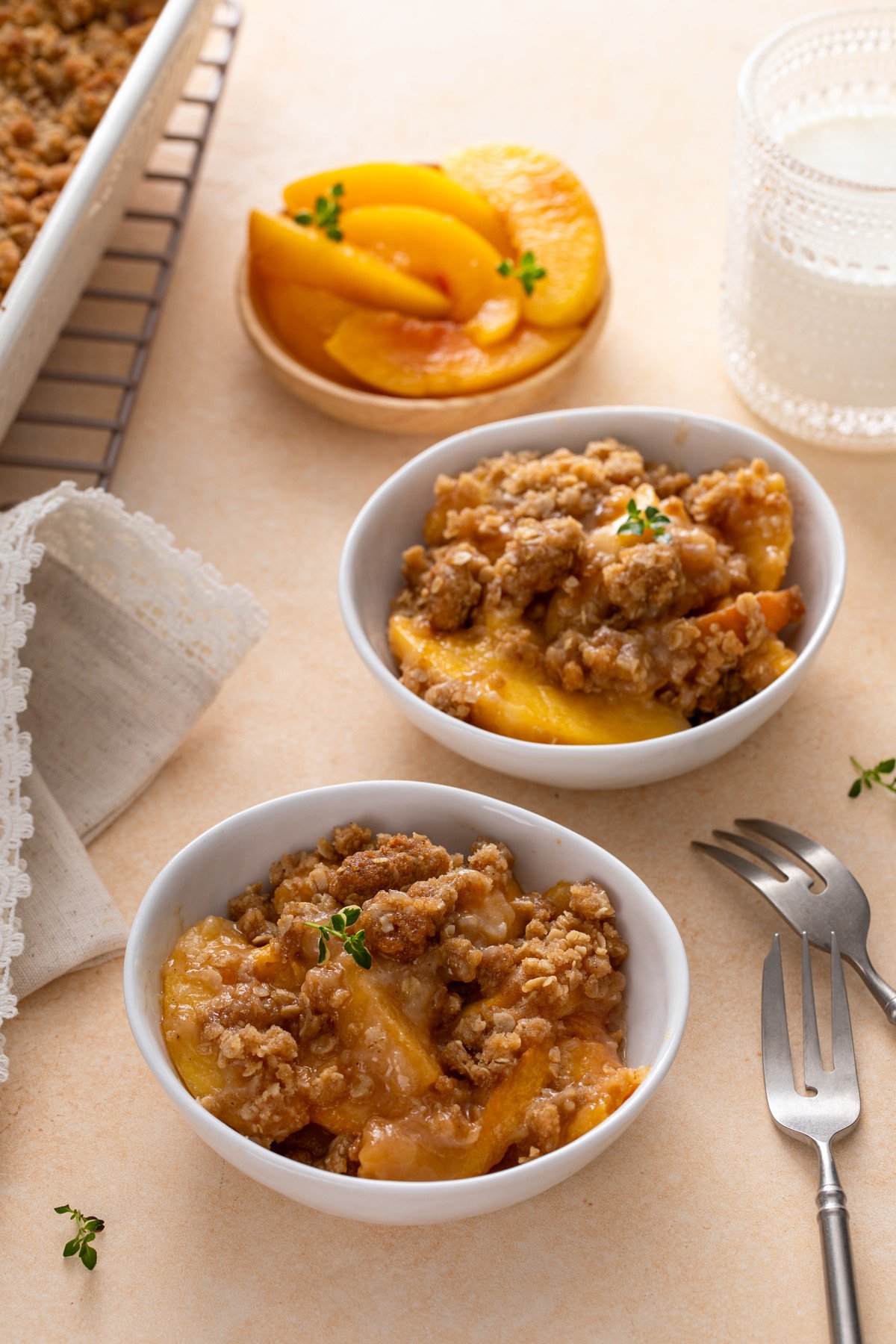 Two white bowls filled with peach crisp.