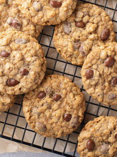 Batch of oatmeal raisin cookies with raisinets cooling on a wire rack.