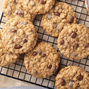 Batch of oatmeal raisin cookies with raisinets cooling on a wire rack.