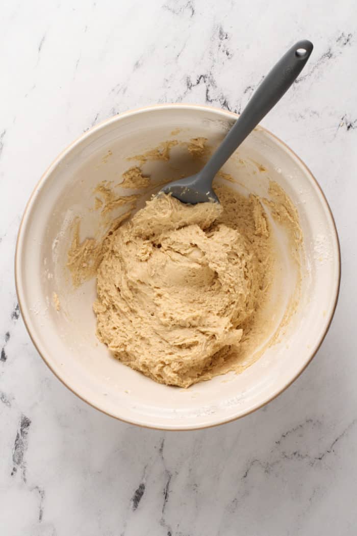 Dough for chocolate glazed donuts in a ceramic mixing bowl.