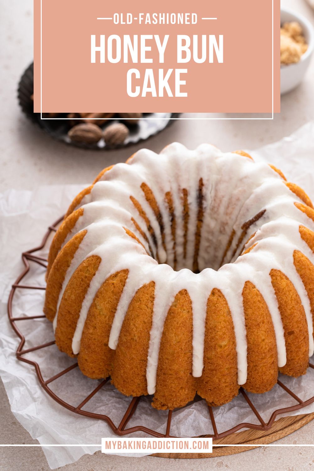 Glazed honey bun cake set on a wire rack, with whole spices visible in the background. Text overlay includes recipe name.