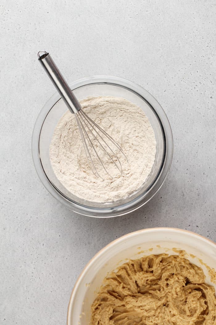 Dry ingredients for cookie dough being whisked together in a glass mixing bowl.