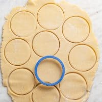 Circle cookie cutter cutting out circles of sugar cookie dough