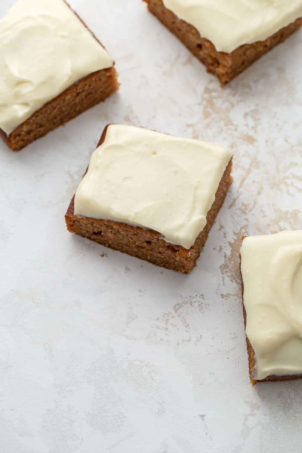 Frosted pumpkin bars sliced and arranged on a white countertop