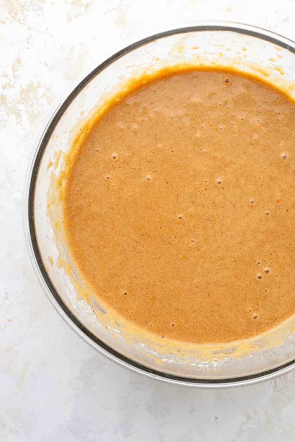 Batter for pumpkin bars in a glass mixing bowl