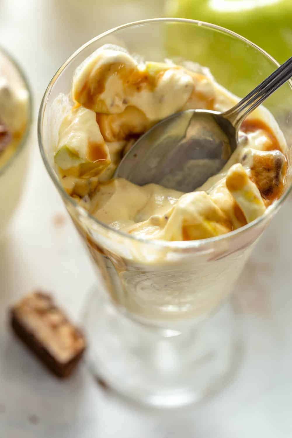 Spoon digging into a serving of caramel apple salad