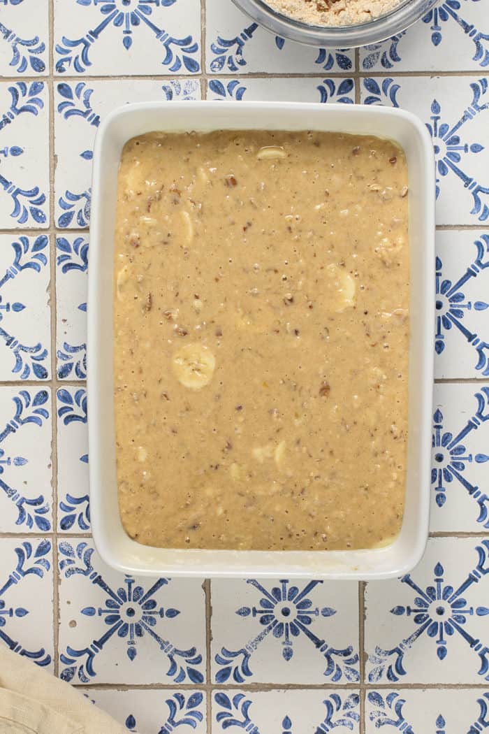 Batter for banana coffee cake spread into a white baking dish