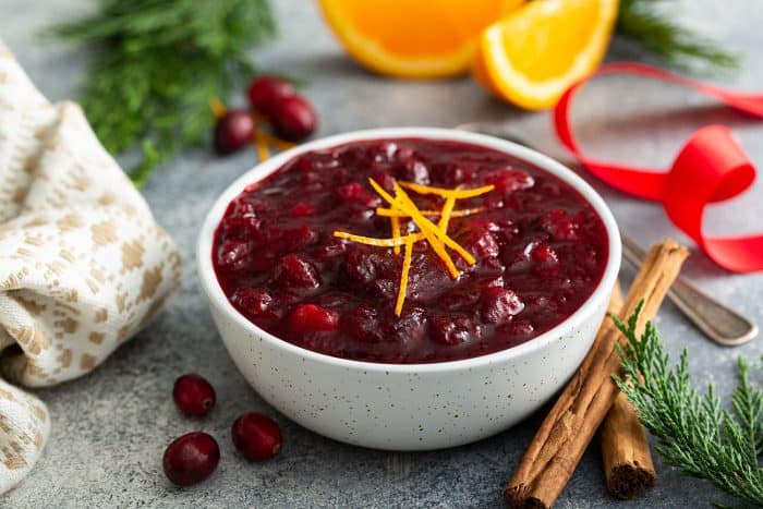 White bowl filled with cranberry sauce on a holiday table