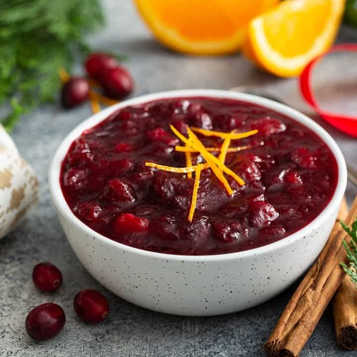 White bowl filled with cranberry sauce on a holiday table