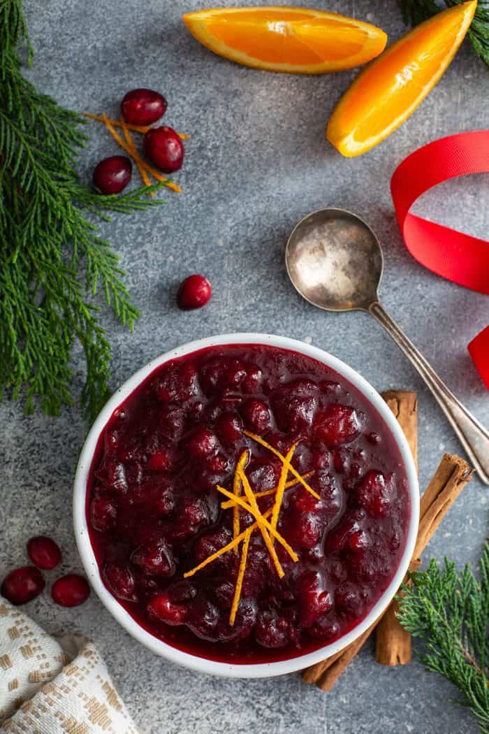 Overhead view of cranberry sauce in a white bowl, set on a holiday table