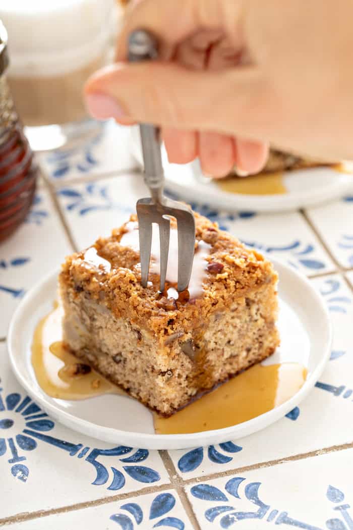 Fork about to take a bite from a plated slice of banana coffee cake