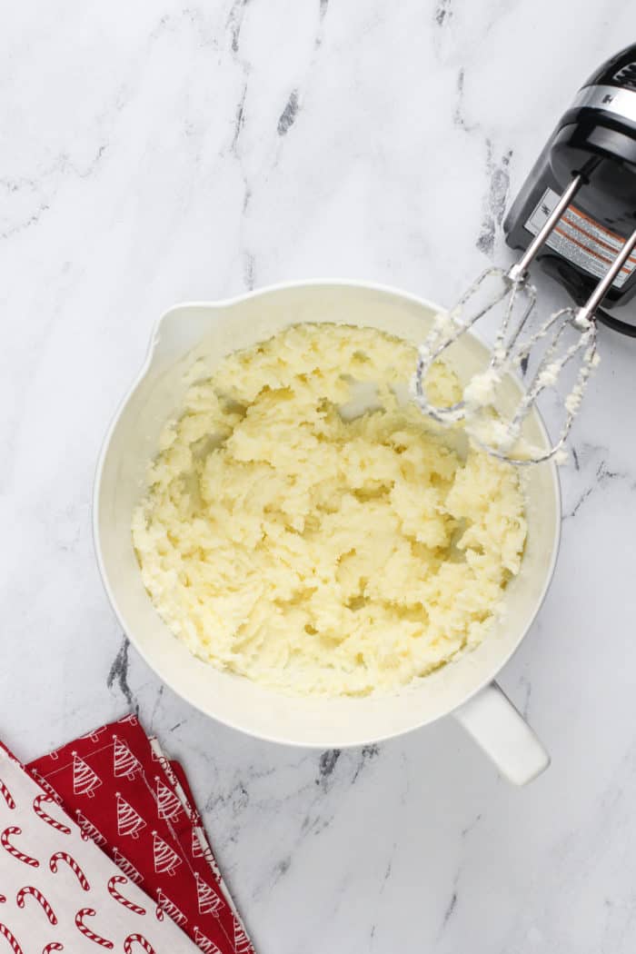 Butter and sugar creamed together in a white mixing bowl.