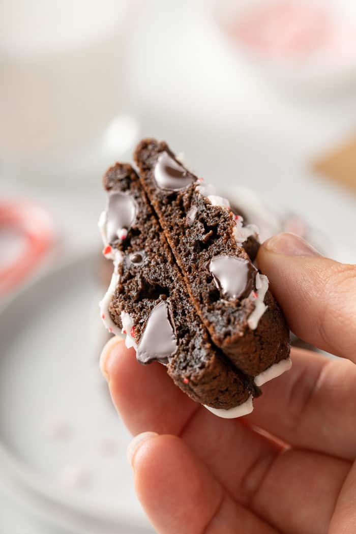 Hand holding up a peppermint mocha cookie that has been cut in half to show the rich inside