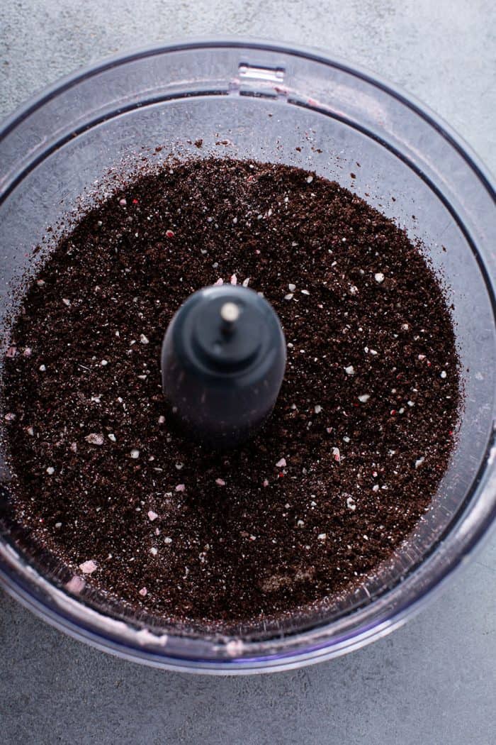 Crushed candy canes and oreo cookies in the bowl of a food processor