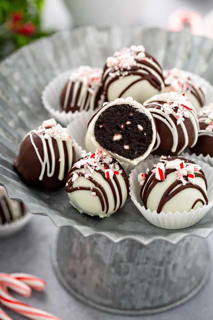 Cut-open Peppermint oreo ball nestled into a pile of oreo balls on a metal platter