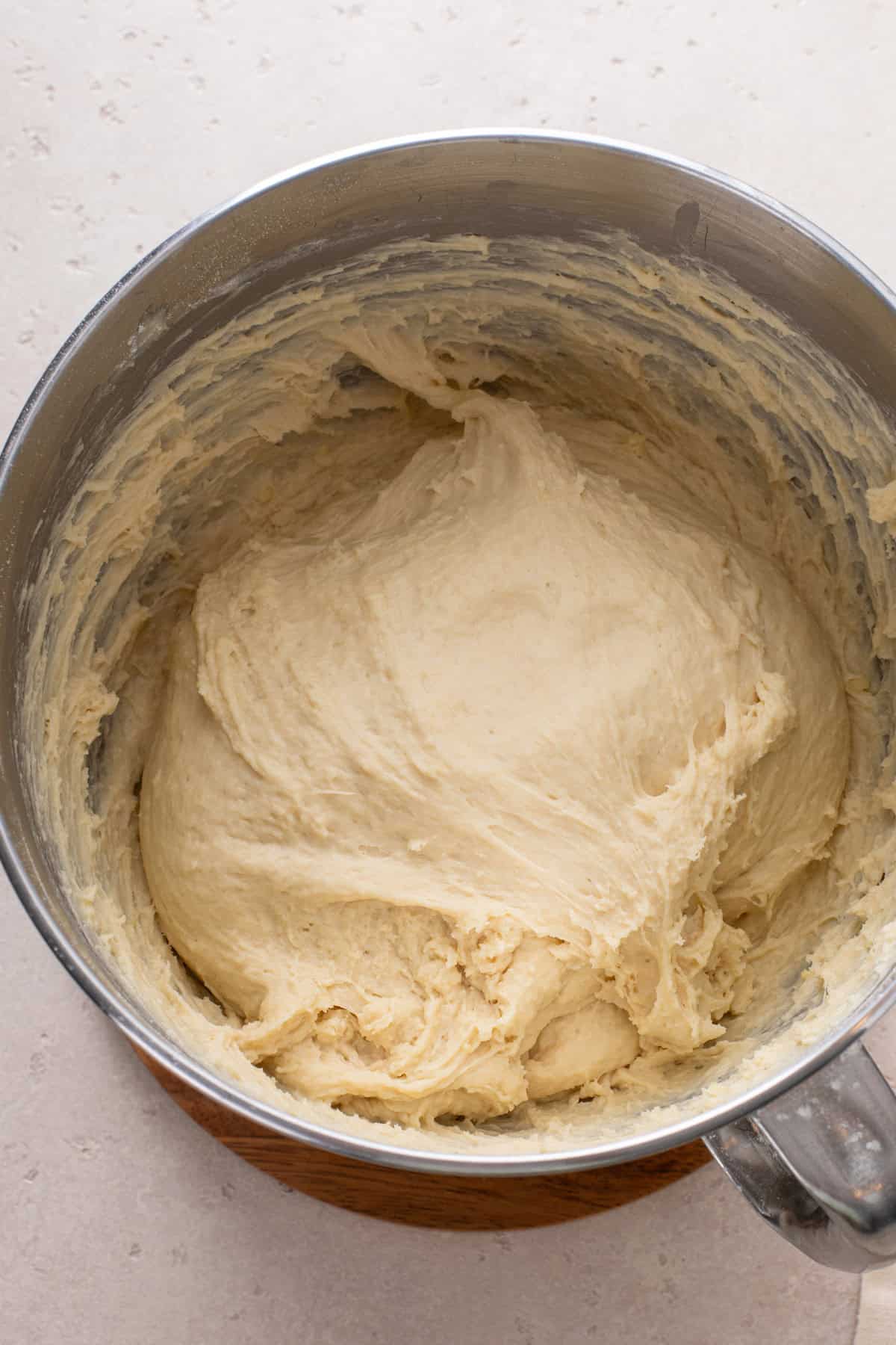 Brown and serve roll dough mixed in a stand mixer bowl.