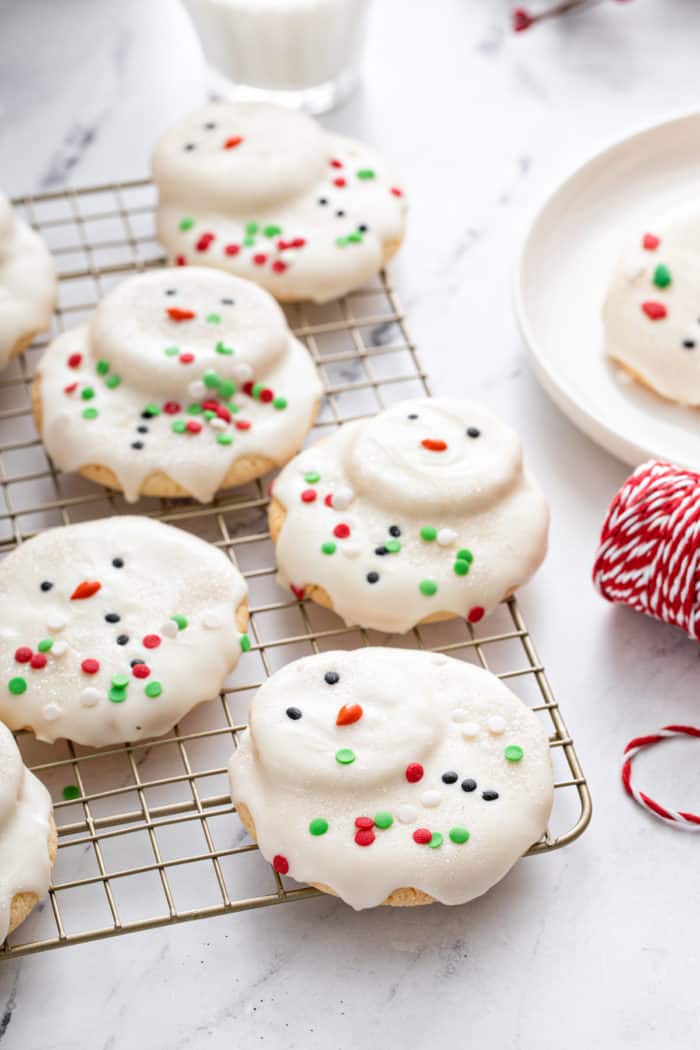 Decorated melted snowman cookies on a wire rack.