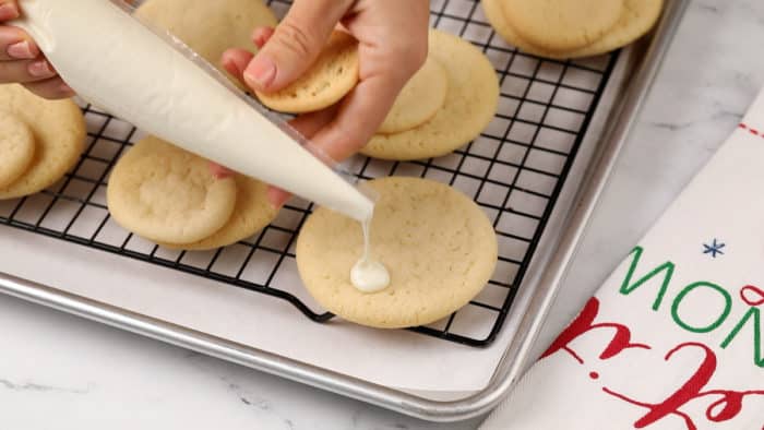 Melted candy melts being dotted onto a large sugar cookie.